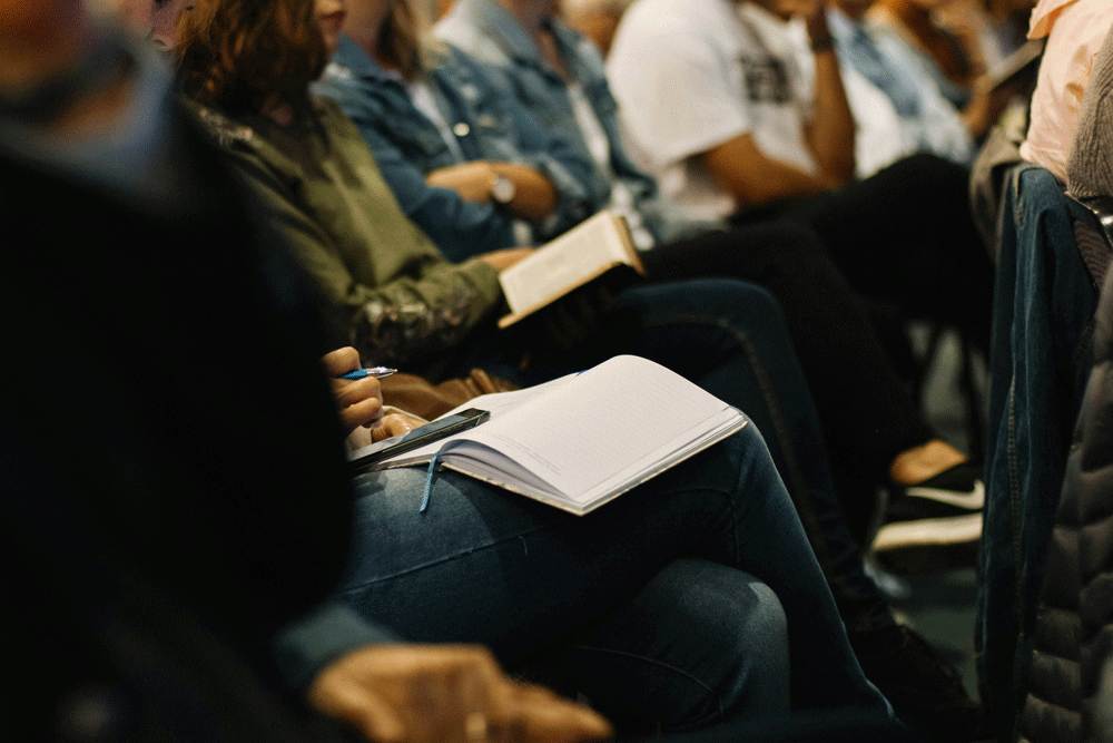 picture of individuals sitting in chairs with open Bibles in their laps